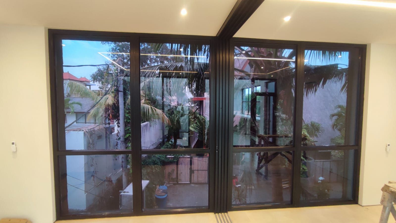 Jendela dan pintu kaca villa di Bali yang sudah dipasang kaca film, pemandangan taman tetap terlihat jelas dari dalam ruangan